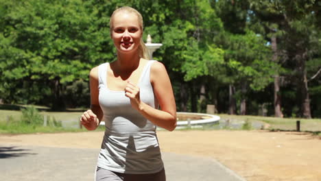 woman jogging in the park towards the camera