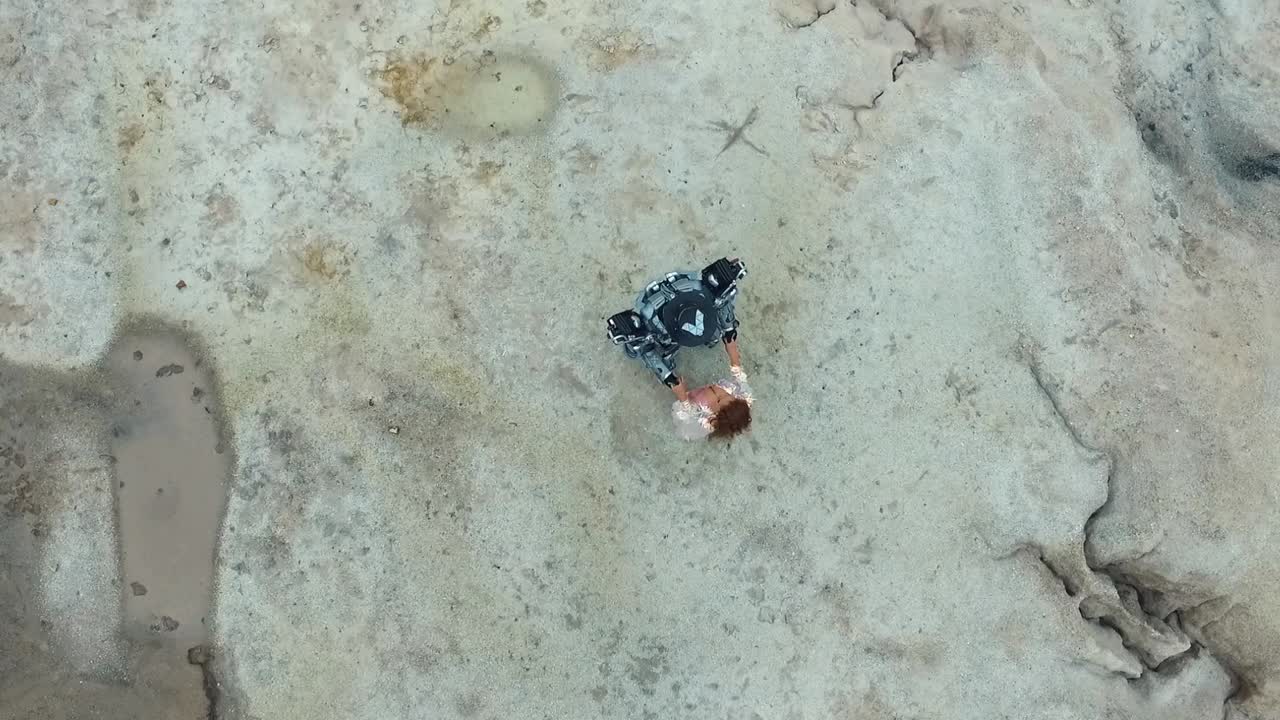 человек, сидящий на скалистой поверхности, взгляд с воздуха