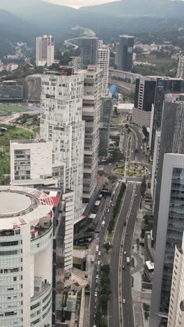 Bird's-eye-view-of-towering-office-and-apartment-skyscrapers-along-renowned-Avenida-Santa-Fe-in-Mexico-City,-vertical-mode