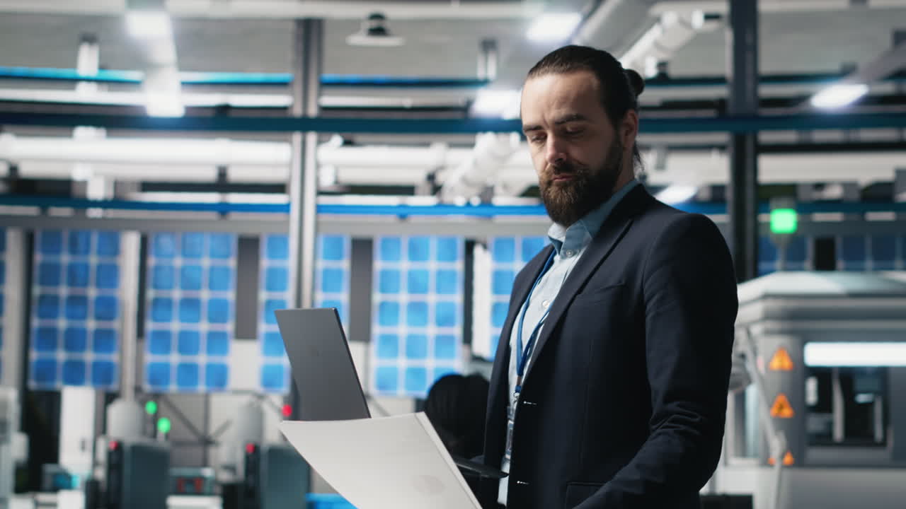 Man working on laptop in a factory setting
