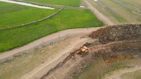 industrial excavator tearing up farmland, destroying fertile soil in the process, a sad reality of land degradation and destruction