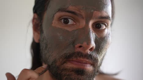 man applying a clay mask for skincare