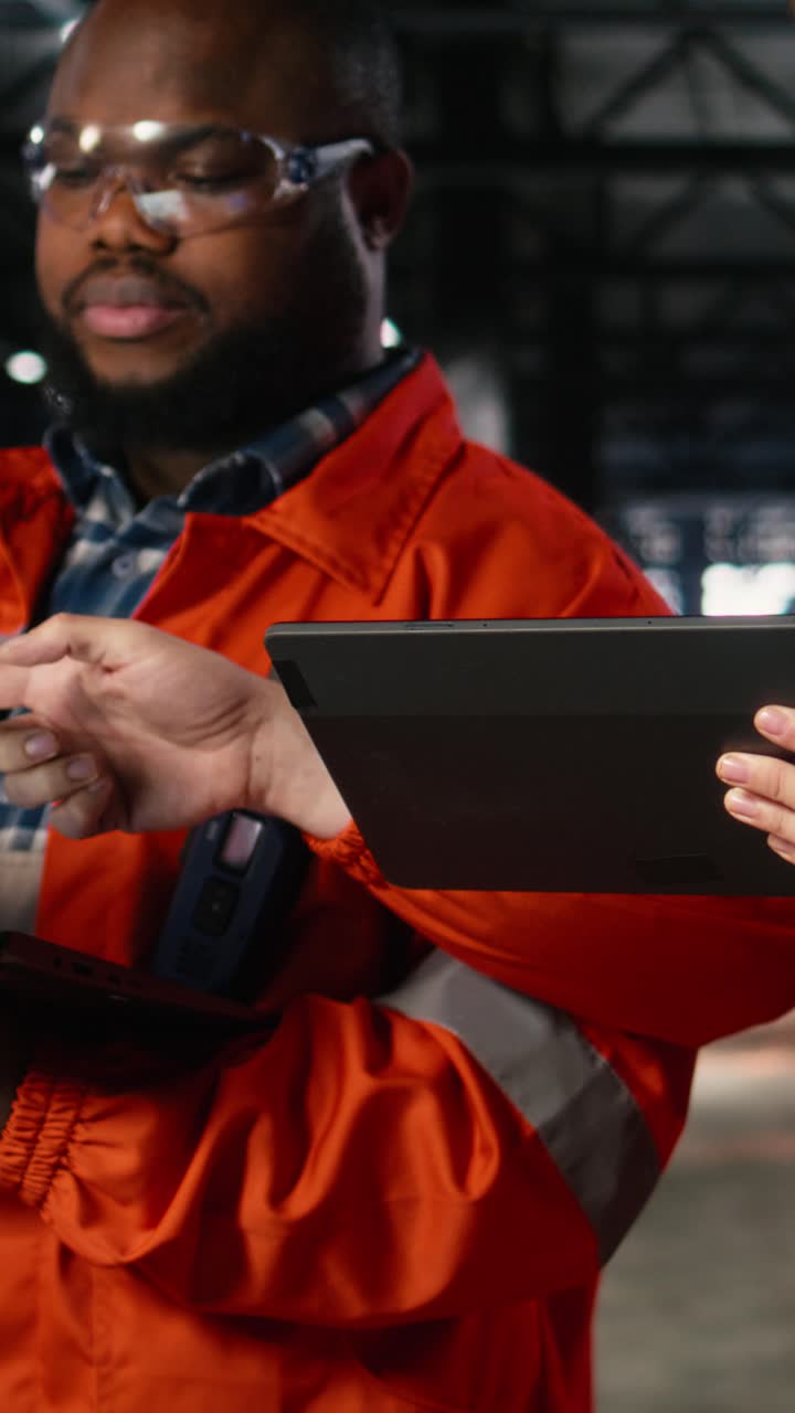Vertical Video Engineers team coordinates strong labor in industry plant with gadgets