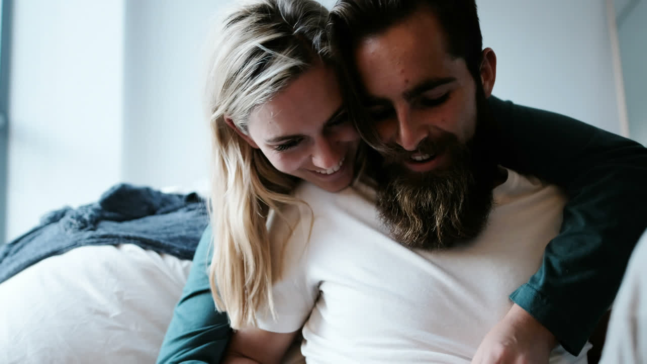 Couple interacting while using mobile phone at home 4k