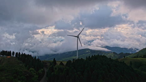 wind turbine against a backdrop of clouds and forests.