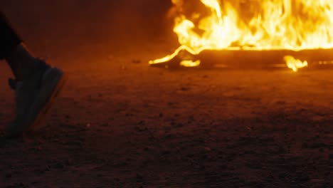 man who dances a moonwalk against the background of a burning car