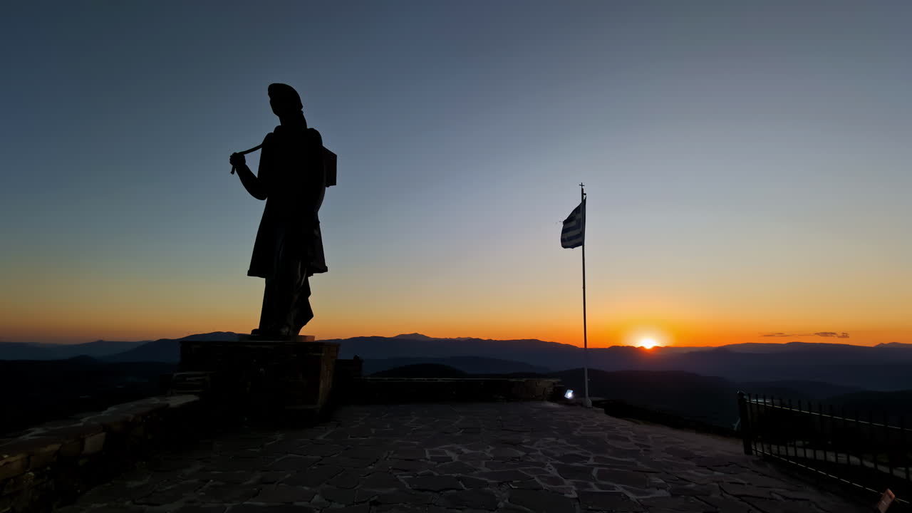 monumento a las mujeres zagorianas y a la bandera griega al atardecer, pindos, grecia