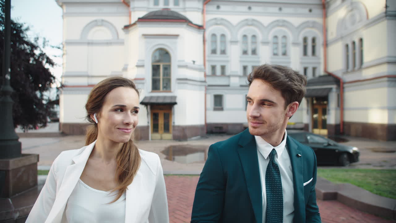 Elegante coppia d'affari che si sorride in città. Persone che camminano all'aperto