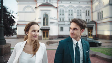 Elegante-Pareja-De-Negocios-Sonriendo-El-Uno-Al-Otro-En-La-Ciudad.-Gente-Caminando-Al-Aire-Libre