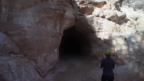 woman with camera entering belly of the dragon man made tunnel in utah usa