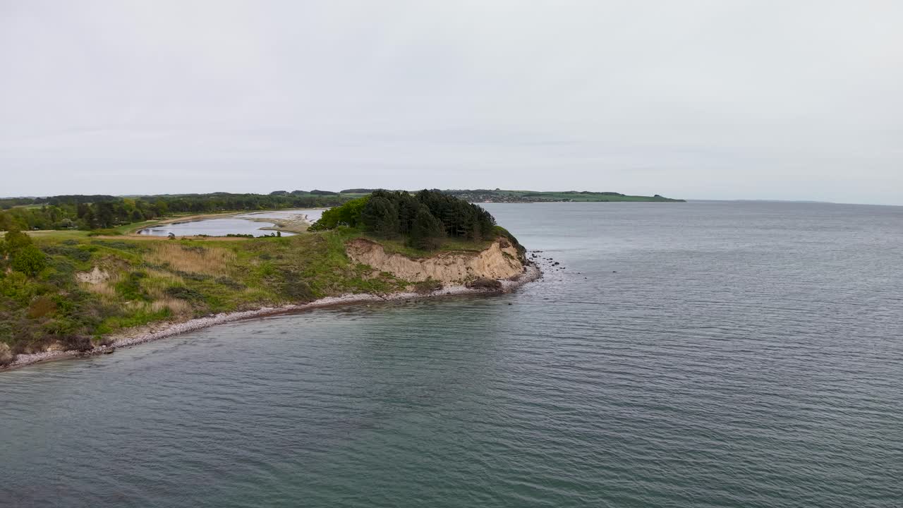 Aerial view of Skodshoved’s curved coastline where the land meets the calm waters of Aarhus Bay