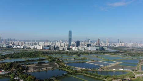 hong kong and shenzhen border line over hong kong rural houses with shenhzen skyline in the horizon, aerial view