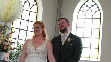 bride and groom standing together in a bright church during their wedding ceremony