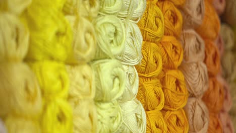 bolas de hilo amarillo, naranja y dorado esperando que los tejedores las compren