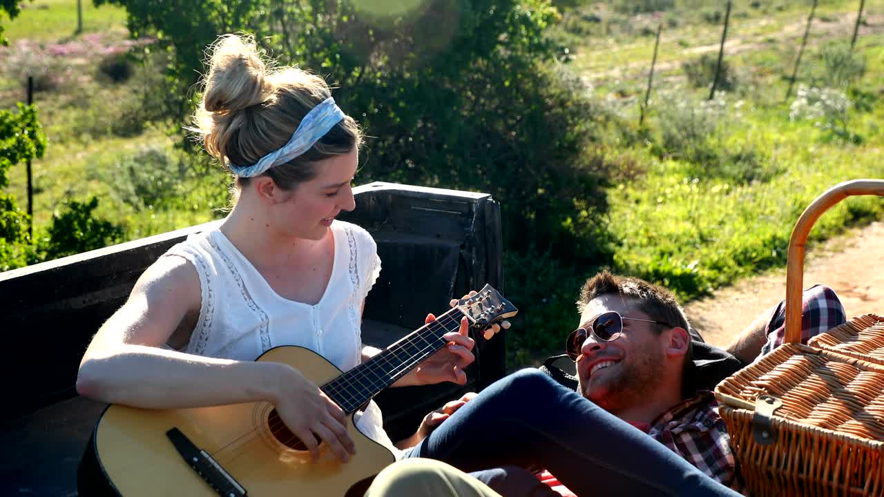 mujer tocando la guitarra para el hombre 4k