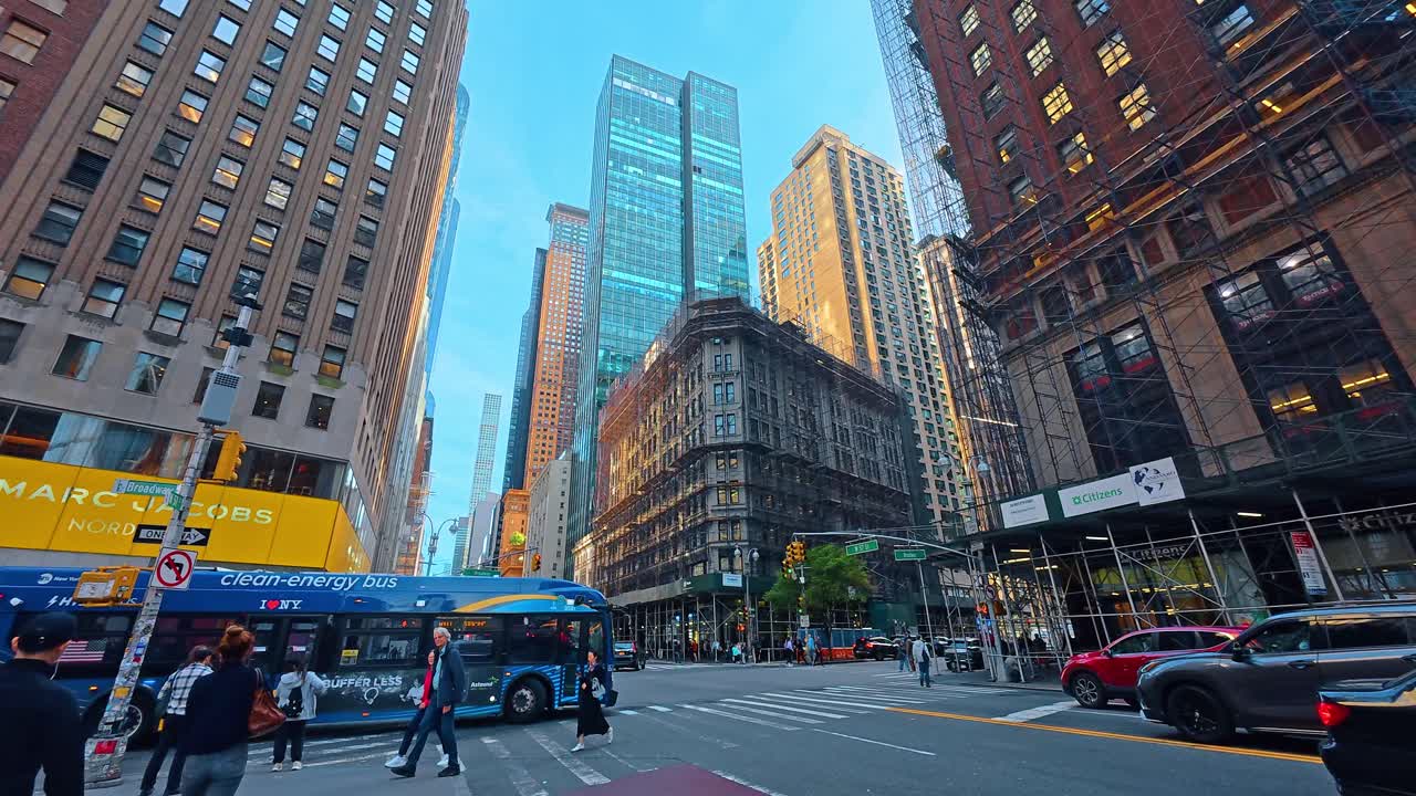 New York, USA, 9 agosto 2025: Affollato incrocio cittadino con autobus blu e moderni grattacieli