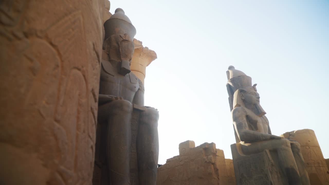 Tall statues in the Karnak Temple, Luxor Egypt. Intricate carved drawings and hieroglyphs adorning the wall.
Slow slide movement sideways.