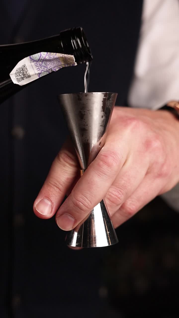 Bartender pouring liquor into a jigger