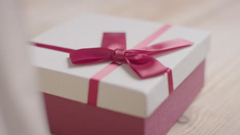 Close-Up-Of-Romantic-Valentines-Present-In-Gift-Wrapped-Box-On-Table