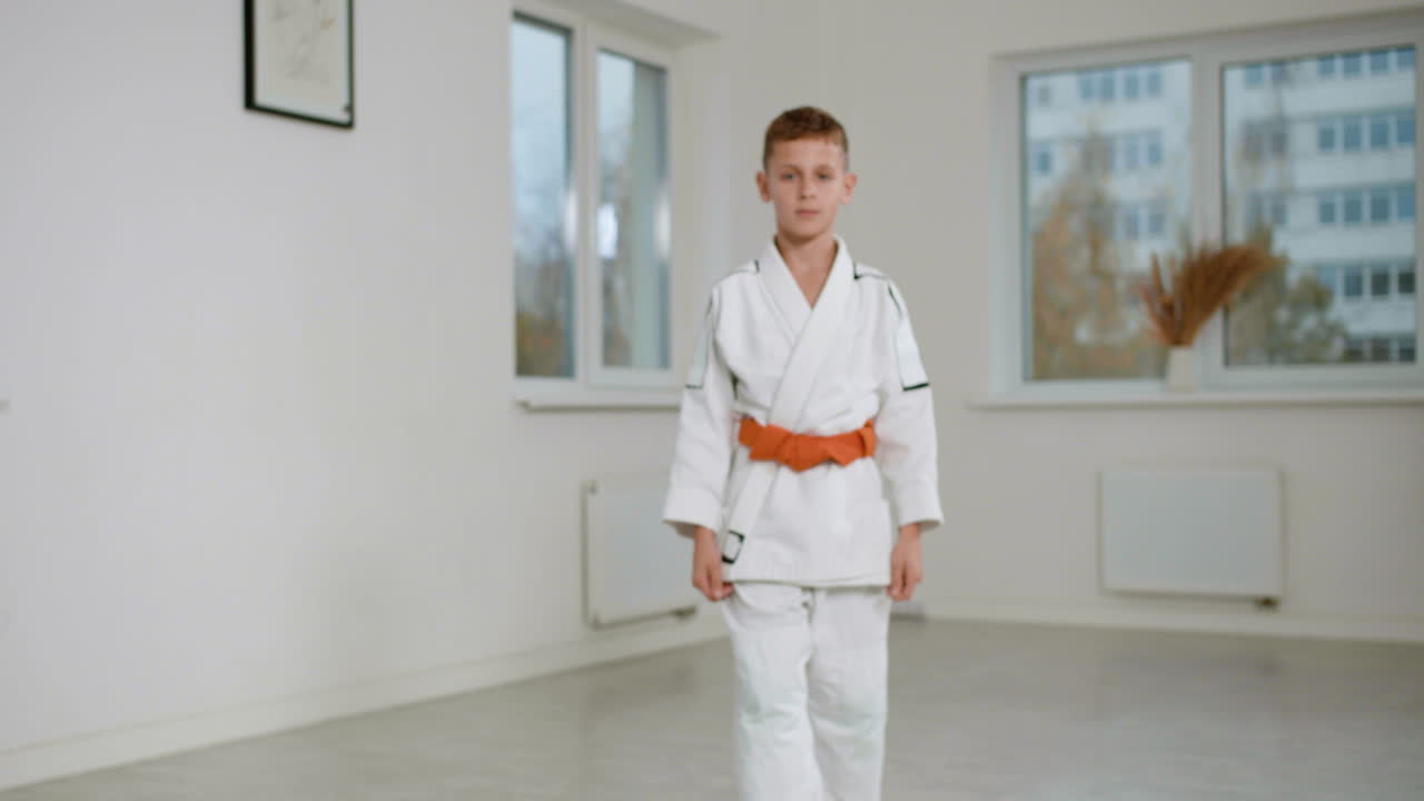 Boy in white kimono in martial arts class