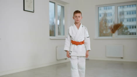 boy in white kimono in martial arts class