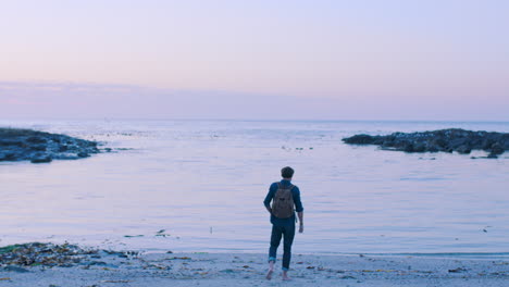 Backpack-man,-walk-and-ocean-sunset-at-the-beach