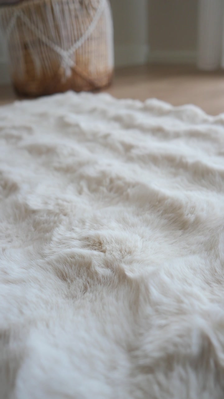 Close-up of a Soft White Faux Fur Rug on a Wooden Floor