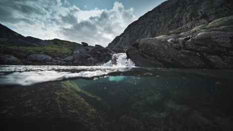 An-over-under-shot-of-the-shallow-river-with-rocky-shores