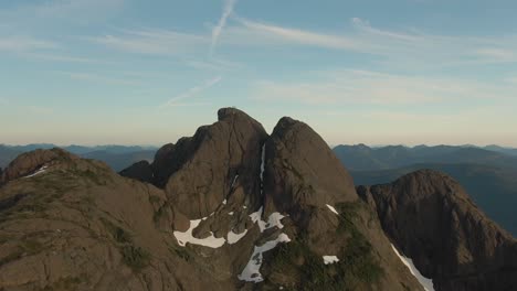 Hermosa-Vista-Aérea-Del-Paisaje-Montañoso-Canadiense-Durante-Una-Vibrante-Puesta-De-Sol-De-Verano