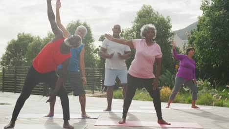 senior diverse people practicing yoga in garden at retirement home