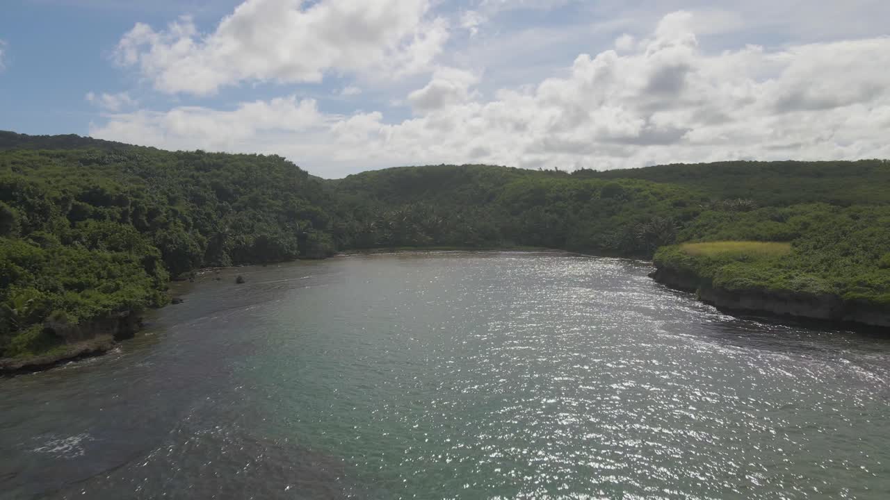 toma aérea moviéndose hacia una bahía de una isla tropical paradisíaca