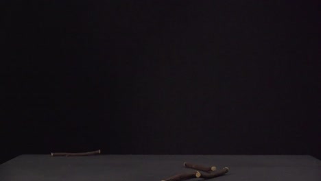 licorice sticks drops at table in 500fps with black background
