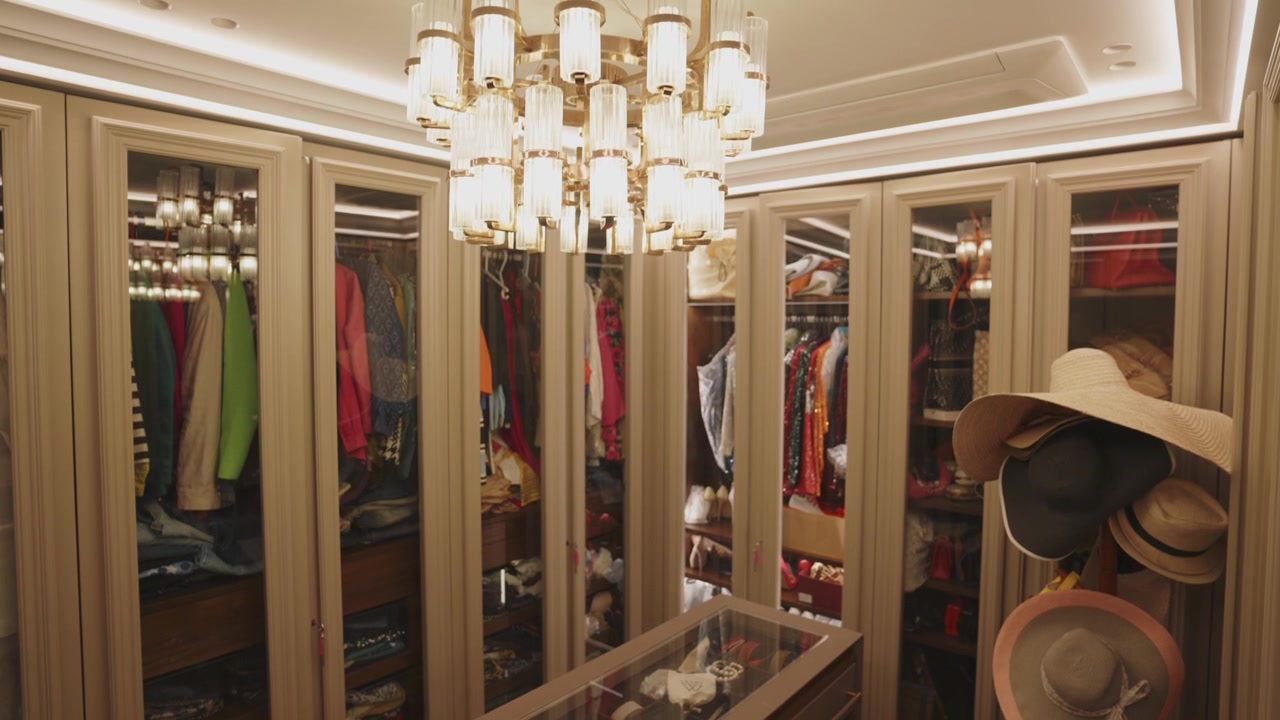Dazzling Gold-Plated and Clear Crystal Chandelier Hanging Inside The Walk-in Closet. tilt-down