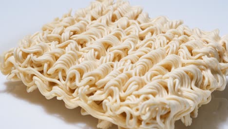 stream of hot water pours into a white bowl wetting a square of dry instant ramen noodles stream of hot water pours into a white bowl wetting a square of dry instant ramen noodles