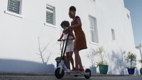 two mixed race women riding electric scooter