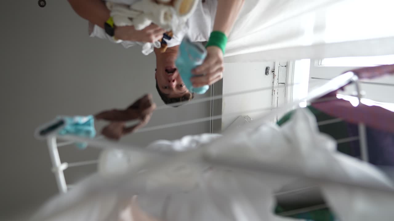 Persona che stende i vestiti su uno stendibiancheria