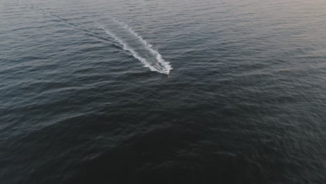 orbiting around a boat splashing over the cold waters off the coast of maine at sunrise aerial