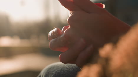 close-up shot of hands rubbing together, suggesting a moment of deep thought or contemplation. the warm lighting and blurred background