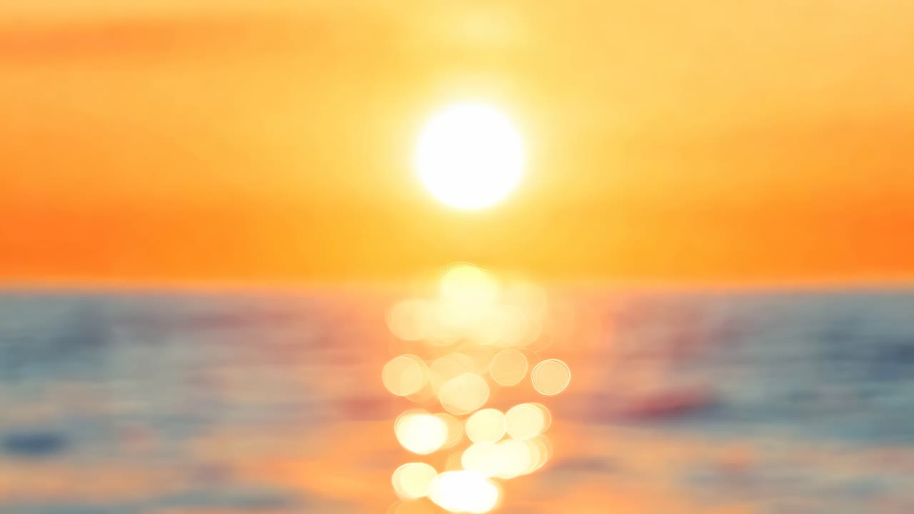 Blurred sunset over ocean with bokeh effect, captured from a low angle