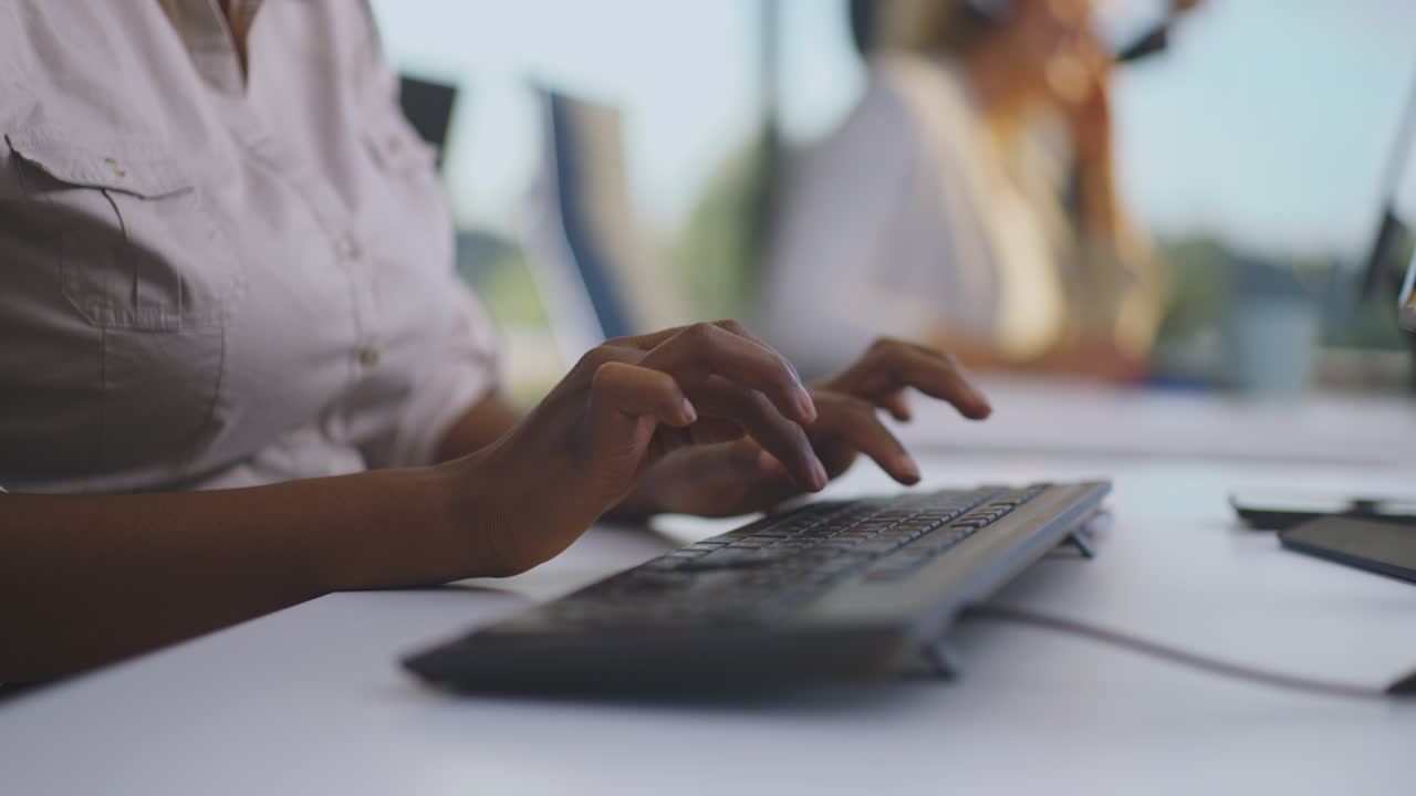mujer escribiendo en un teclado en una oficina