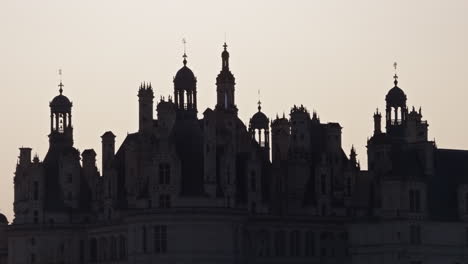 silhouette of château de chambord at dusk, historic royal castle in rural france