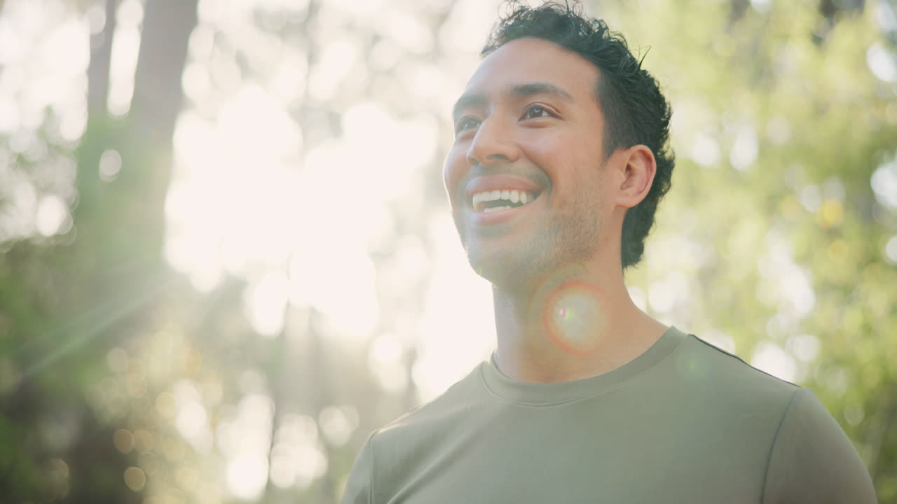 Young Man Drinks Water from Bottle Outdoors and Smiles