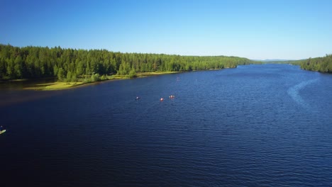 aerial footage of a group of people out kayaking on a river in the sun