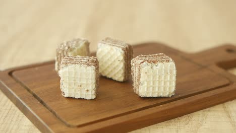 close up of chocolate wafer cookies on a wooden cutting board