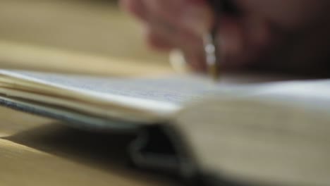 Closeup long static shot, writing hands place ballpoint pen in sketch notebook