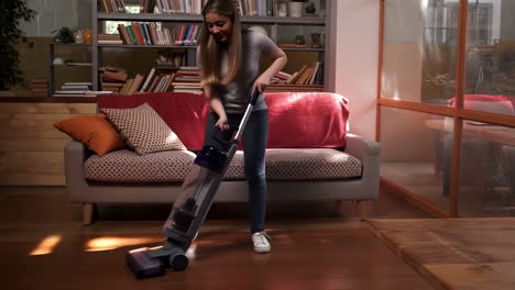young woman cleaning hardwood floor with vacuum cleaner