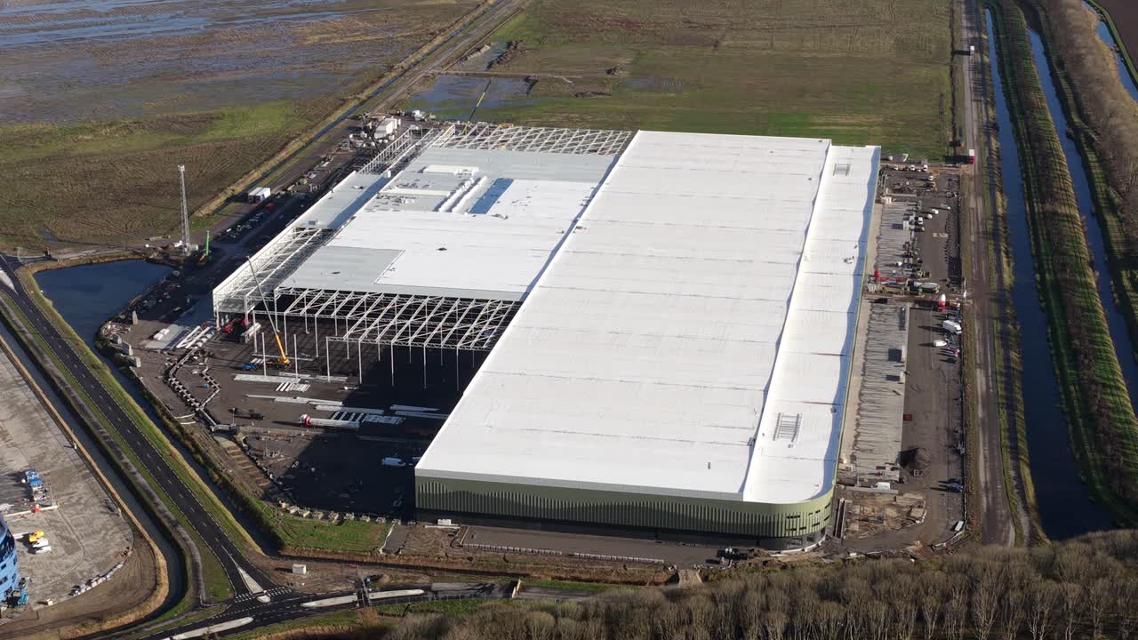 Aerial drone video of a new warehouse under construction at Logistics Park Moerdijk, Netherlands. Highlights massive logistics space development, corporate expansion, and industrial investment