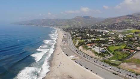 drone footage taken from 400 feet of zuma beach with waves rolling across the soft white sand