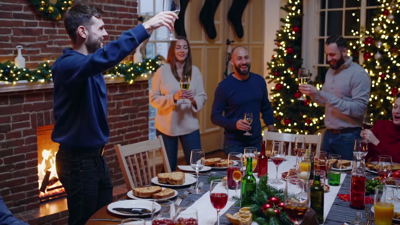 Festive dinner party scene captured from a wide-angle, showcasing friends toasting by a fireplace