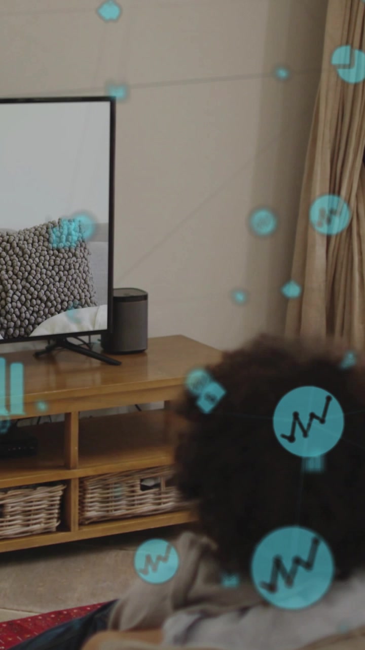 Video verticale: Ragazzo su un tappeto che guarda la TV, icone di dati blu che fluttuano dalla TV alla testa, per insegnare finanza.
